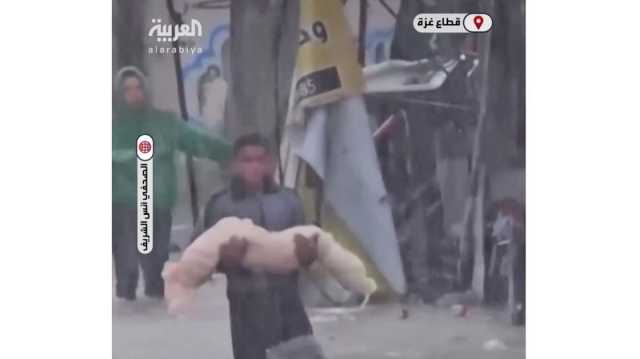 تفاصيل مشهد من غزة يدمي القلب.. نازح يحمل جثة طفلة بين مياه الأمطار