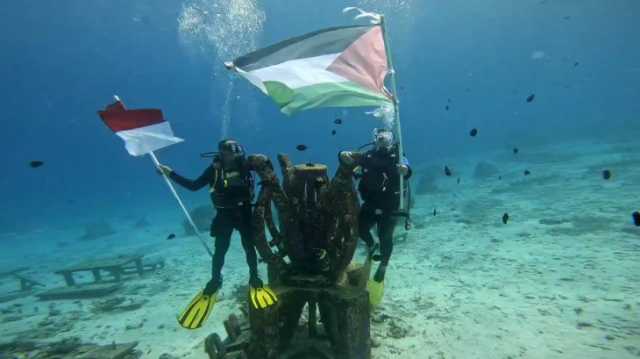 غواصان يرفعان علمي فلسطين وإندونيسيا في قاع مياه جزيرة إندونيسية