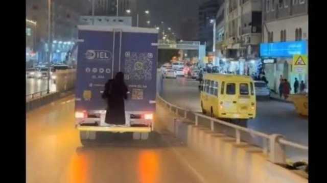 سيدة تثير ضجة في السعودية بعد تعلقها بسيارة نقل (فيديو)