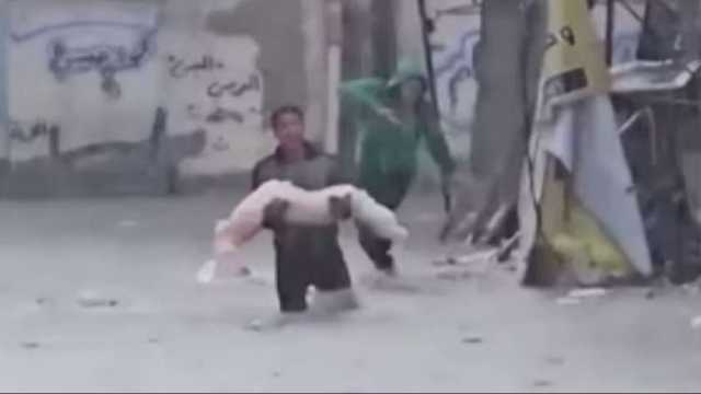 مشهد مأساوي وسط دمار غزة.. فسلطيني يحمل جثة بين يديه وسط السيول