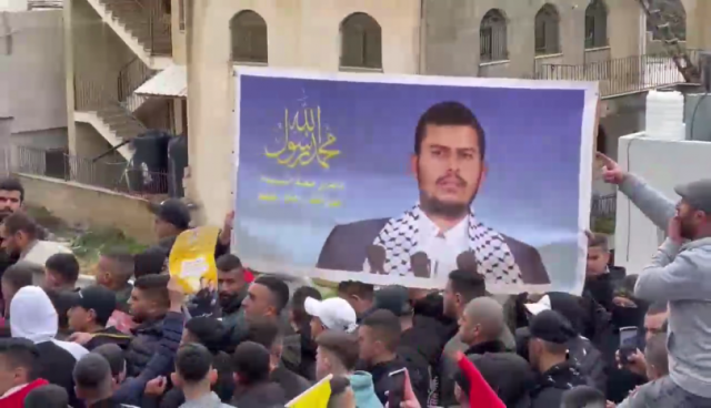 رفع صورة كبيرة ملفتة لـ قائد حركة أنصار الله عبدالملك الحوثي في رام الله (فيديو)