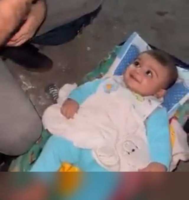 شاهد .. ضحكات طفل غزاوي نجى من الموت بأعجوبة بعد قصف إسرائيل لمنزل أسرته (فيديو)
