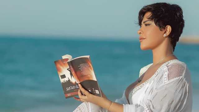 شمس الكويتية تثير الجدل بفستان مكشوف من أمام البحر وبيدها كتاب