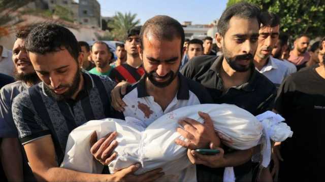 أب فلسطيني يوجه رسالة دعم للمقاومة وهو يحمل طفله الشهيد (شاهد)