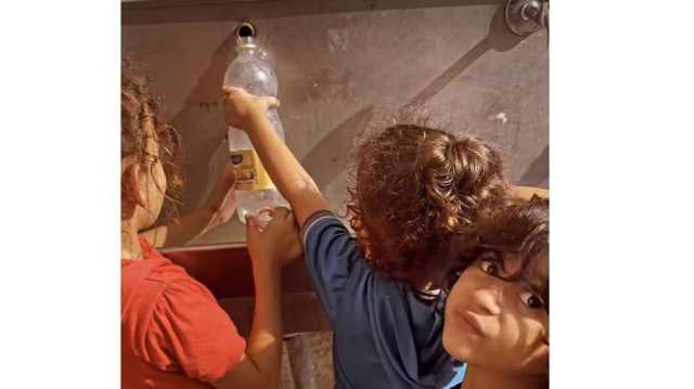مشاهد مؤلمة.. أطفال يجمعون قطرات المياه من شدة العطش في غزة (شاهد)