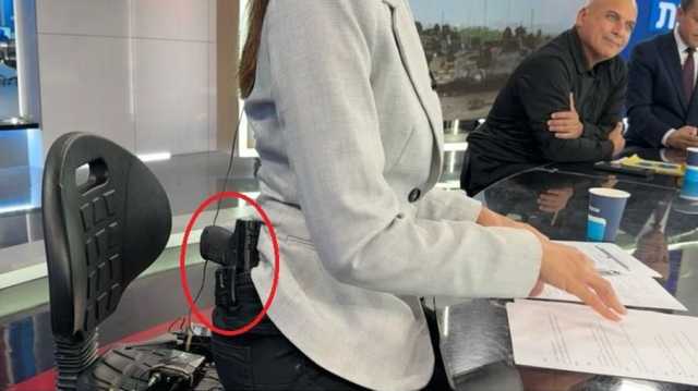 مذيعة إسرائيلية تحمل سلاحا على خصرها داخل أستديو الأخبار (شاهد)