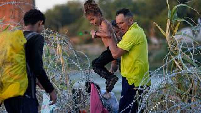 مهاجرون يعبرون النهر ويخترقون الأسلاك الشائكة على الحدود بين المكسيك والولايات المتحدة